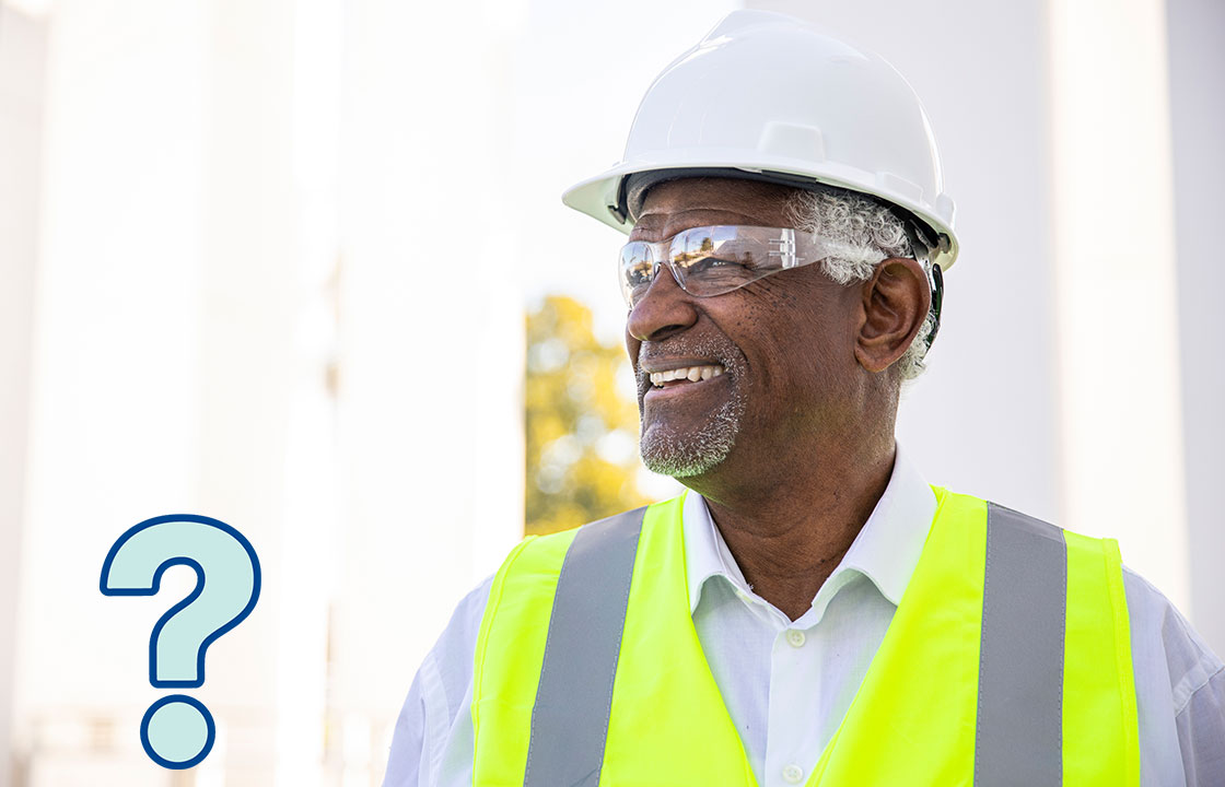 senior man in a construction hat and vest